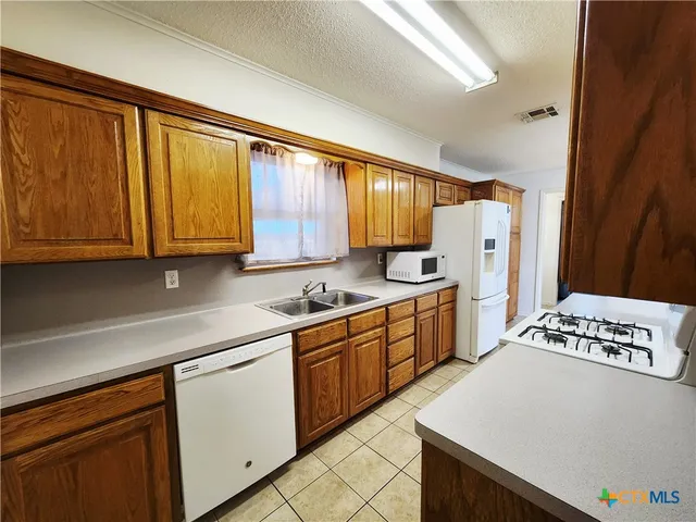 a kitchen with stainless steel appliances a refrigerator sink and cabinets