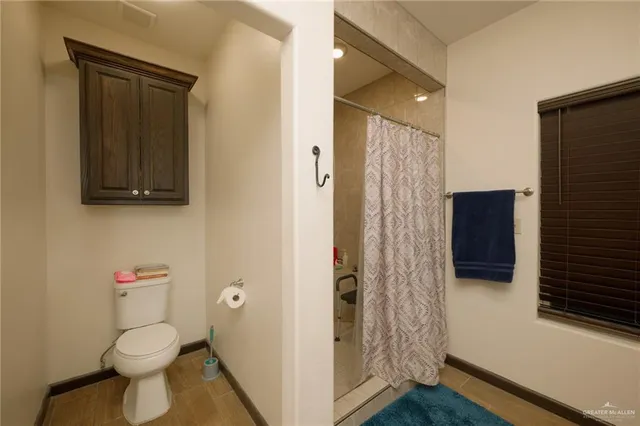 a bathroom with a toilet and a shower