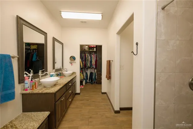 a en suite bathroom with sink double vanity and mirror