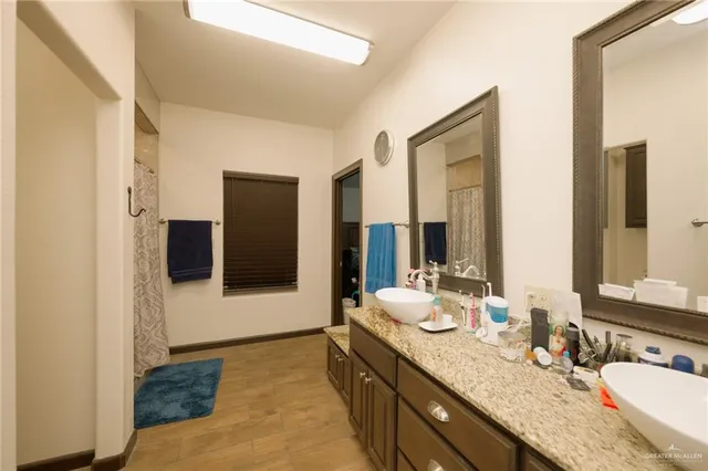 a bathroom with a granite countertop double vanity sink and a mirror