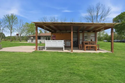 a view of a house with a backyard and a patio