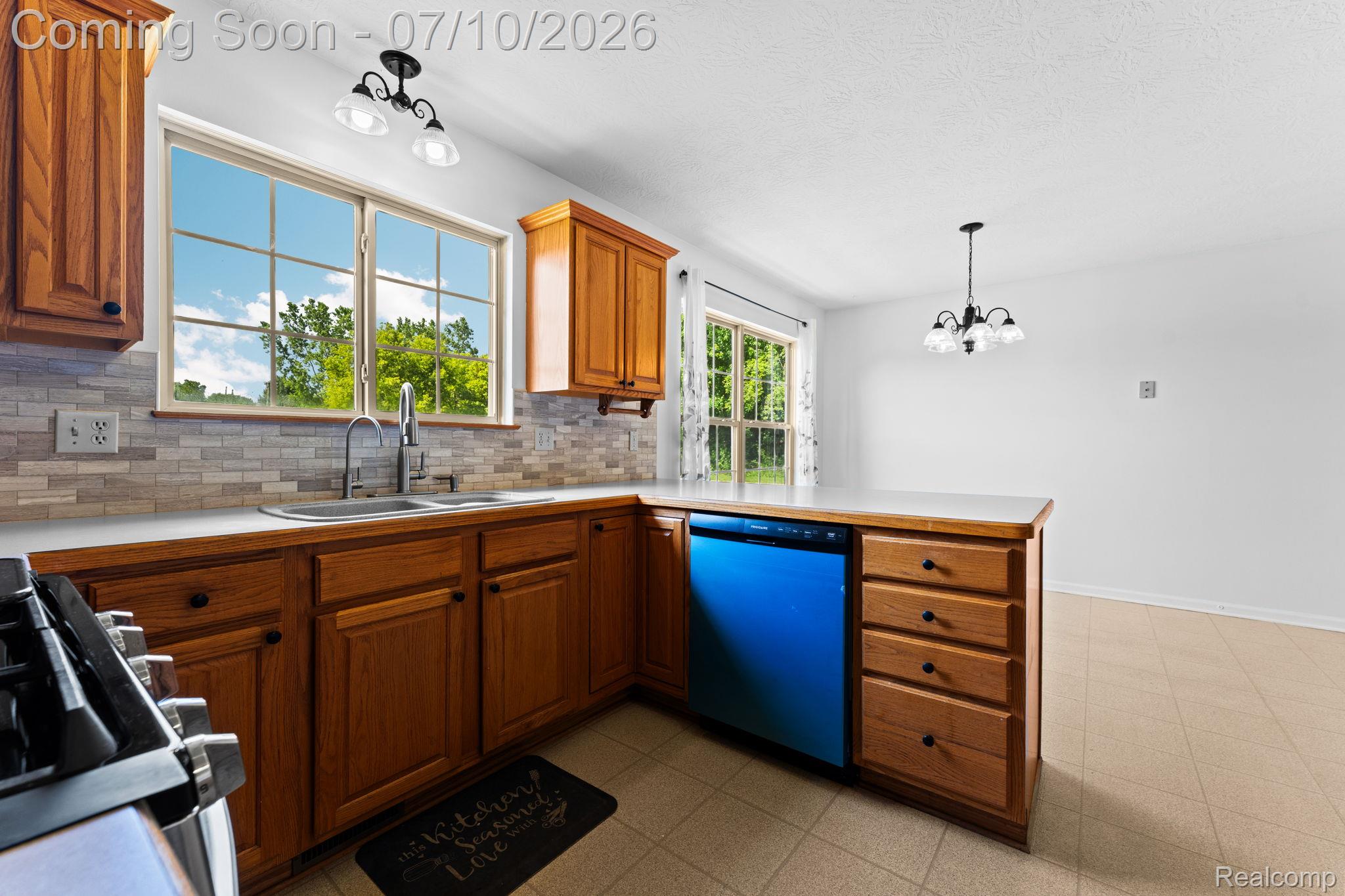 3144 North Nicholson Road Fowlerville, MI 48836 - Photo 42 of 70 Kitchen featuring wood cabinetry, light countertops, and a subway tile backsplash