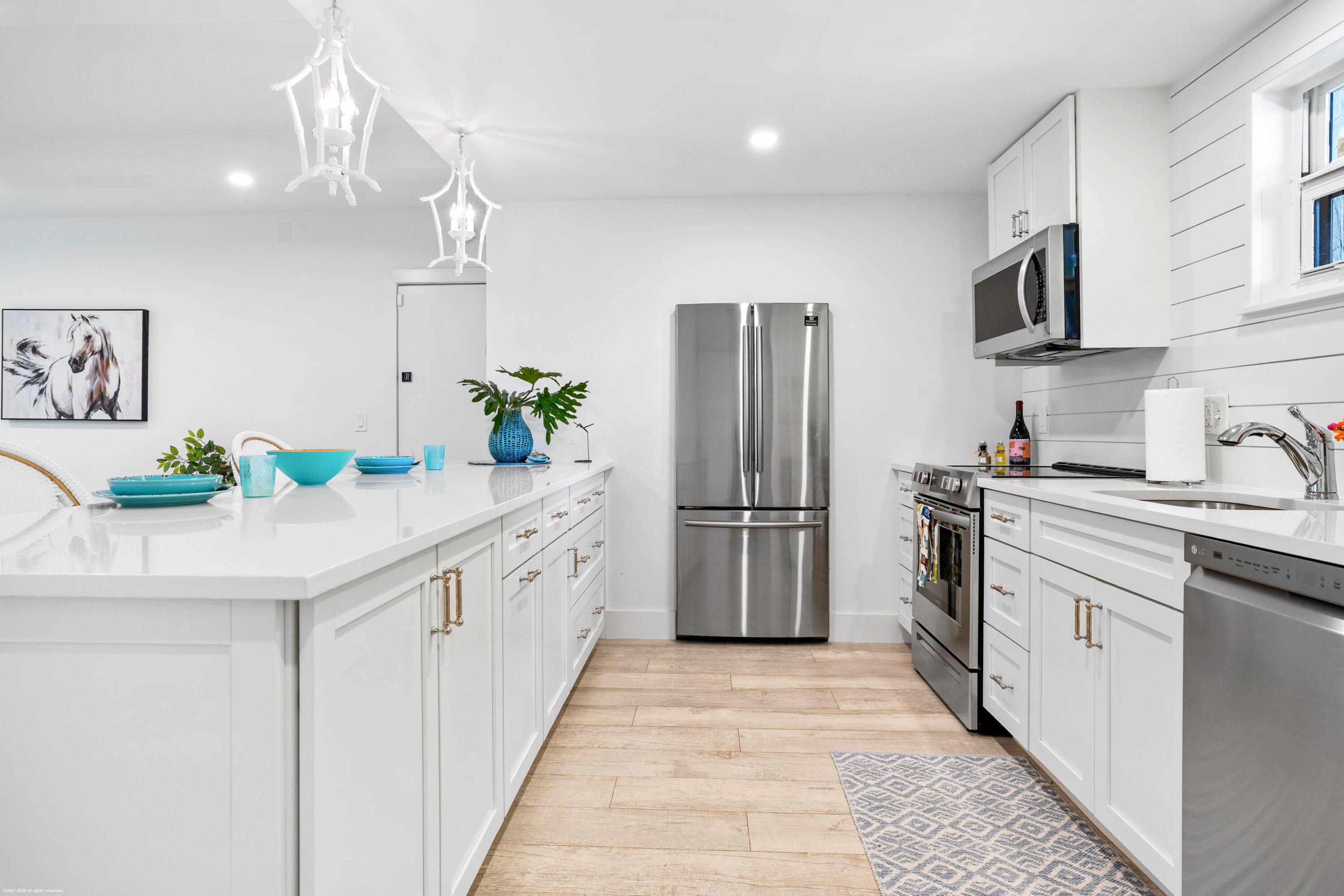 13334 Polo Club Road, Unit 234 Wellington, FL 33414 - Photo 8 of 41 a kitchen with stainless steel appliances kitchen island granite countertop a refrigerator a stove a sink dishwasher and white cabinets with wooden floor