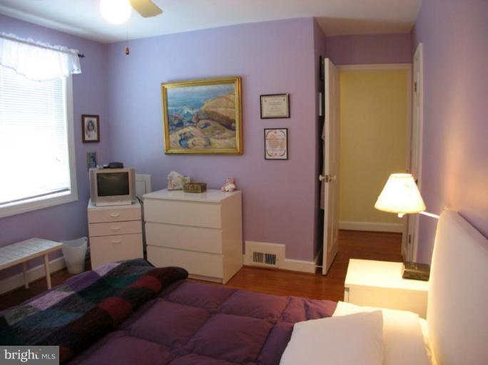 605 Deepdene Road Baltimore, MD 21210 - Photo 14 of 30 a bedroom with a bed and a lamp on dresser