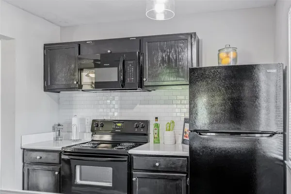 a kitchen with a refrigerator and a stove top oven