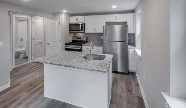 a kitchen with stainless steel appliances granite countertop a refrigerator and a stove top oven