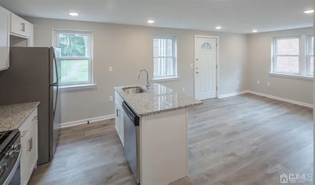a kitchen with granite countertop a refrigerator and a sink