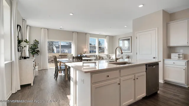 a kitchen with white cabinets and sink