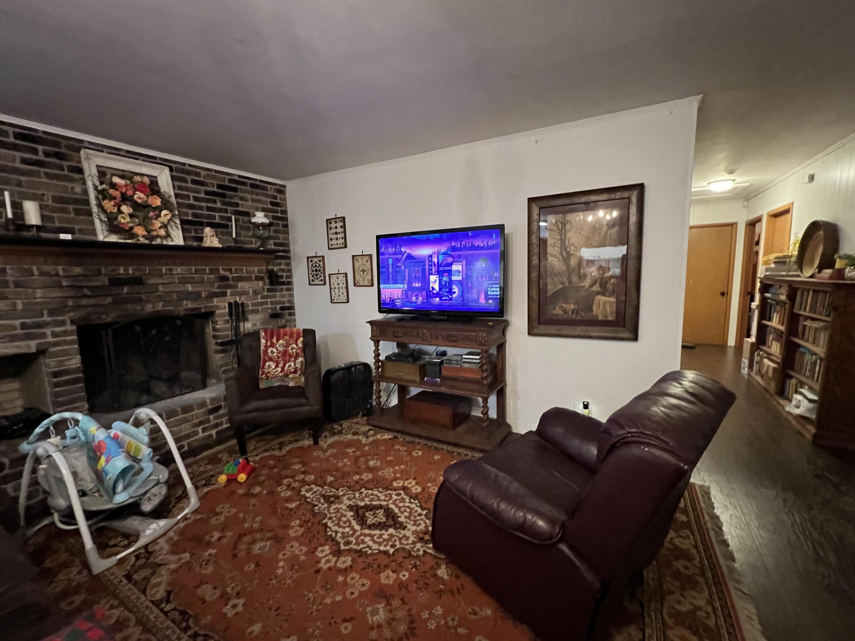 3211 Maple Street Crestview, FL 32539 - Photo 9 of 41 a living room with furniture a flat screen tv and a fireplace