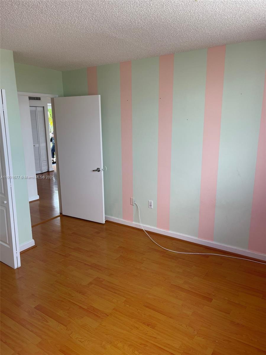 8251 Northwest 8th Street, Unit 414 Miami, FL 33126 - Photo 18 of 25 an empty room with wooden floor and entrance