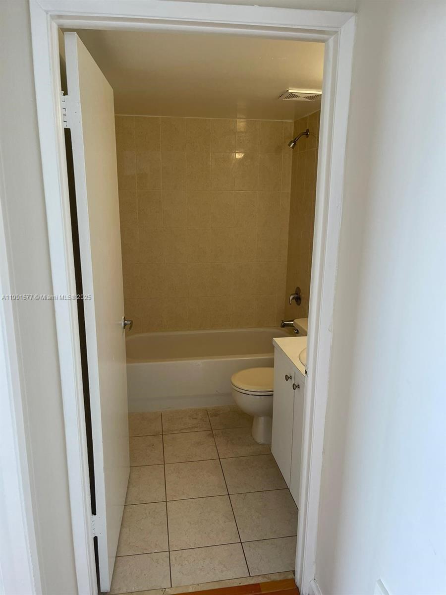 8251 Northwest 8th Street, Unit 414 Miami, FL 33126 - Photo 20 of 25 a bathroom with a granite countertop toilet and a shower