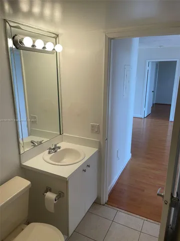 a kitchen with white cabinets stainless steel appliances and a sink