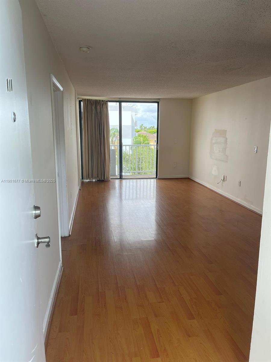 8251 Northwest 8th Street, Unit 414 Miami, FL 33126 - Photo 6 of 25 wooden floor in an empty room with a window