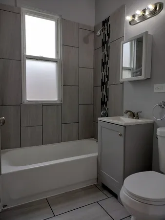 a bathroom with a bathtub a window and a shower