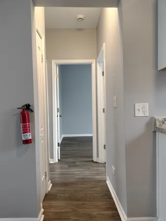 a view of a hallway with wooden floor and closet