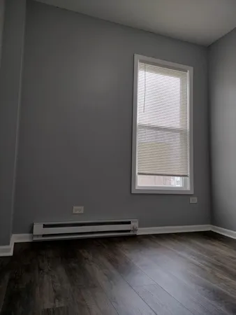 an empty room with a hardwood and window