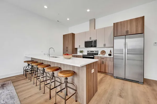 a kitchen with kitchen island a refrigerator a stove a sink and a refrigerator