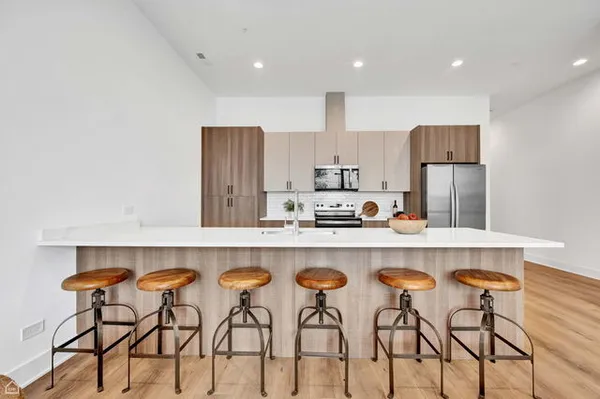 a kitchen with stainless steel appliances granite countertop a table chairs sink and cabinets
