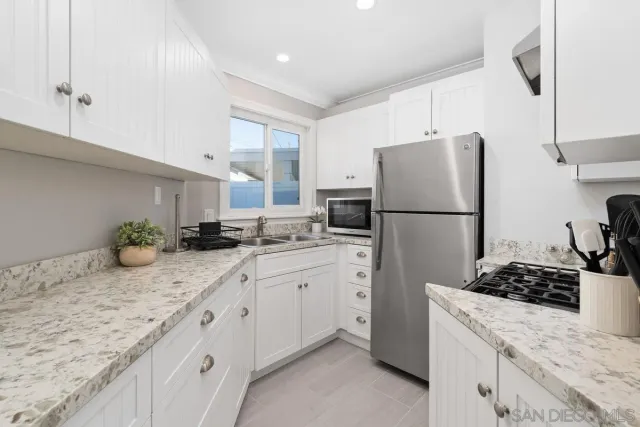 a kitchen with sink refrigerator and stove