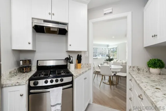 a kitchen with a stove and a wooden floor