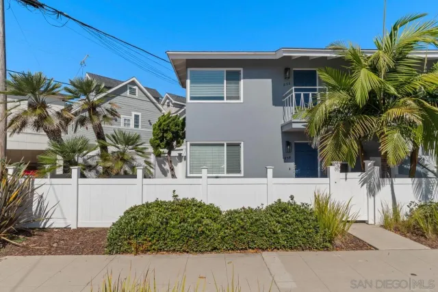 a front view of a house with a yard and potted plants