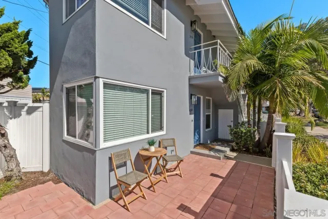 a view of brick house with a chairs and table in a patio