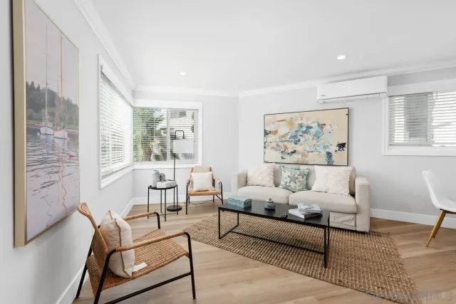 a living room with furniture and a large window with wooden floor
