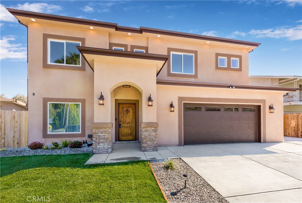 26210 Larkhaven Place Newhall, CA 91321 - Photo 2 of 29 a front view of a house with a garden and plants