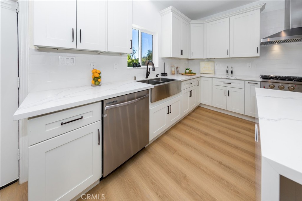 26210 Larkhaven Place Newhall, CA 91321 - Photo 8 of 29 a kitchen with white cabinets and white appliances