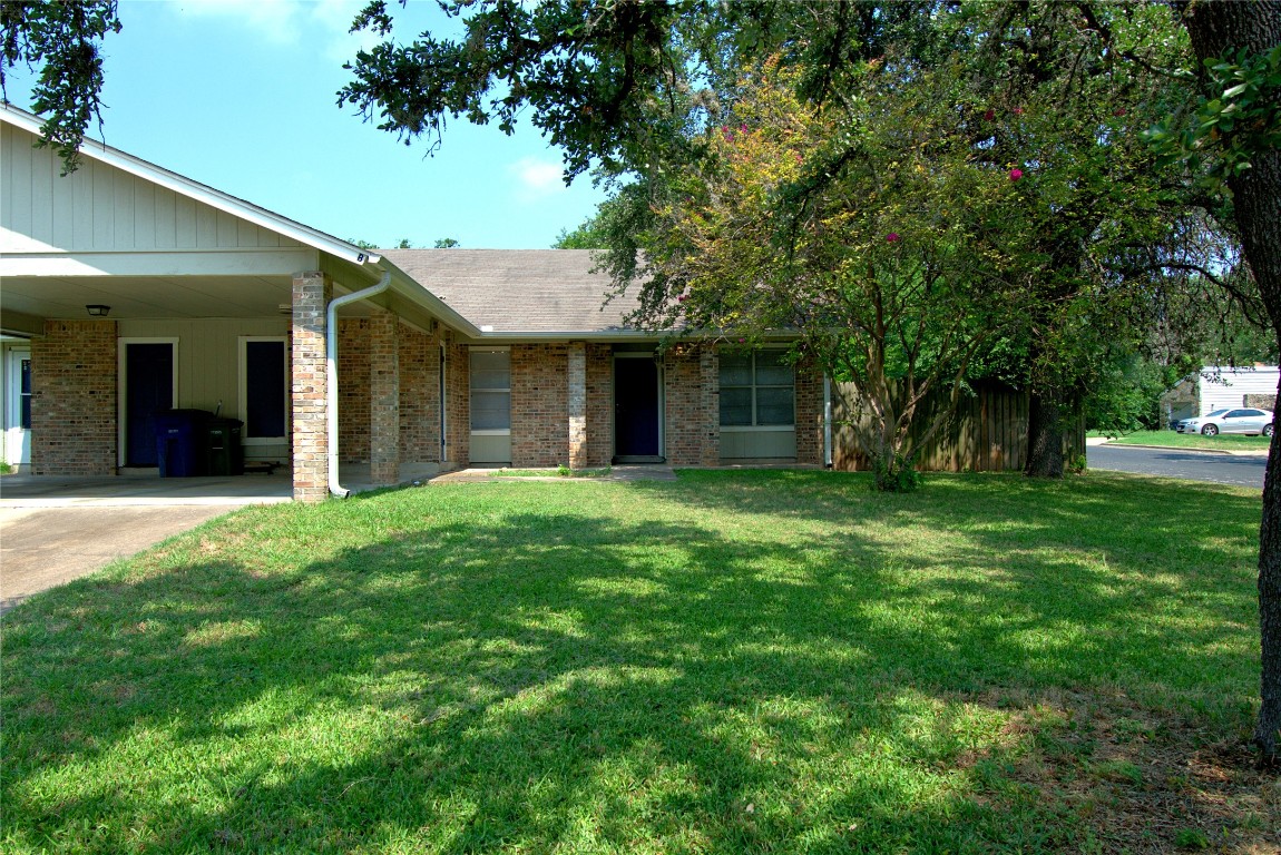 a view of a house with a yard and tree