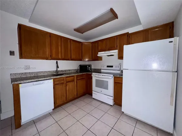 a kitchen with granite countertop cabinets stainless steel appliances and a sink