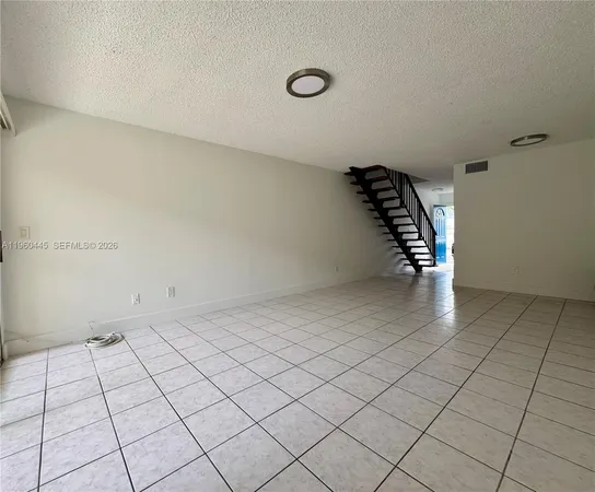 a view of an empty room and staircase