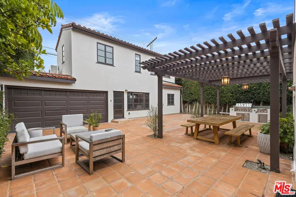 a view of a patio with couches table and chairs and potted plants