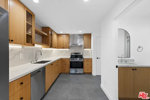 a kitchen with stainless steel appliances a sink stove and cabinets