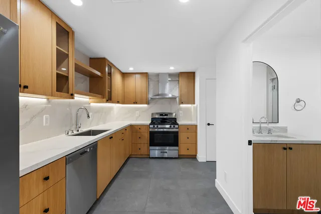 a kitchen with stainless steel appliances a sink stove and cabinets