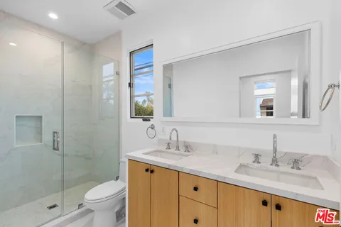 a bathroom with a granite countertop sink toilet and shower