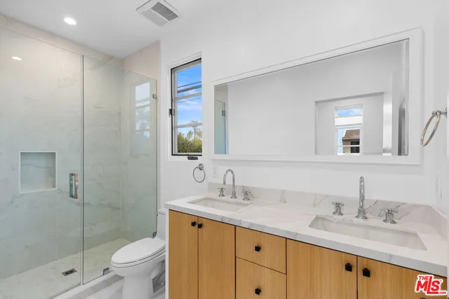 a bathroom with a granite countertop sink toilet and shower
