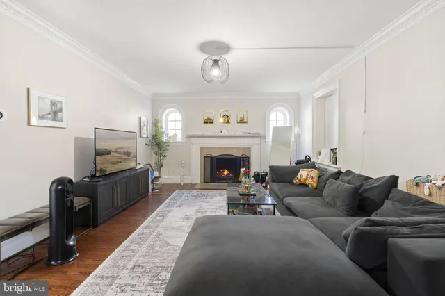 a living room with furniture wooden floor and a window