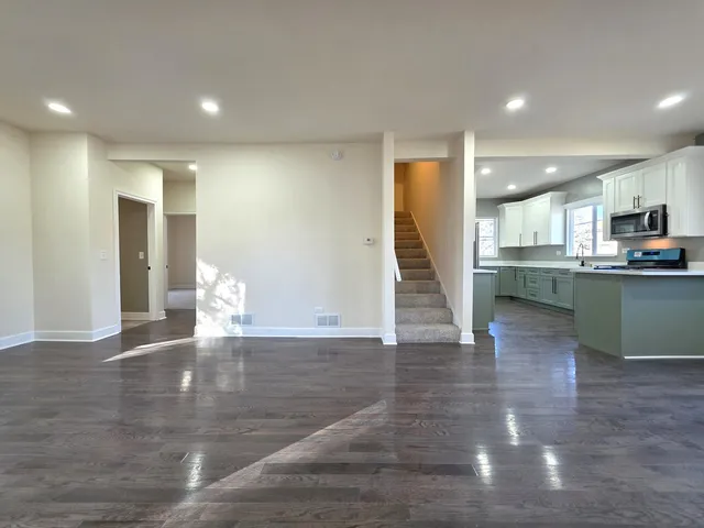 a view of a kitchen with a sink and an empty room