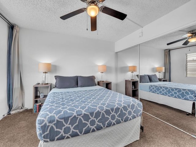 a bedroom with a large bed and a chandelier