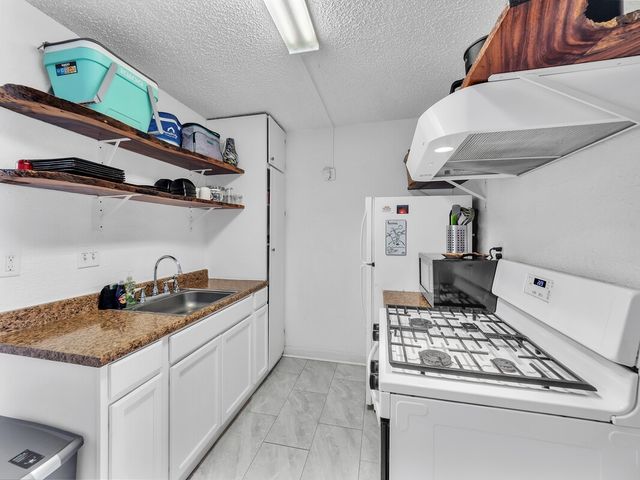a kitchen with stainless steel appliances granite countertop a sink stove and cabinets