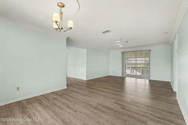 a view of empty room with wooden floor and window