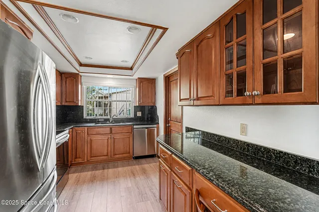 a kitchen with stainless steel appliances granite countertop a refrigerator and wooden cabinets