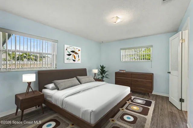 a bedroom with a bed and a dresser next to a window