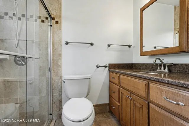 a bathroom with a granite countertop toilet sink and shower