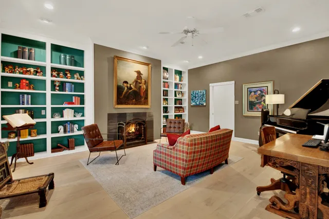 a living room with furniture a bookshelf and a fireplace