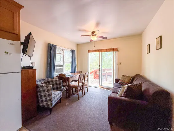 a living room with furniture ceiling fan and a window