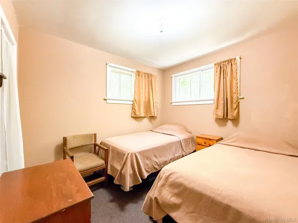 a bedroom with two beds and painting on the wall