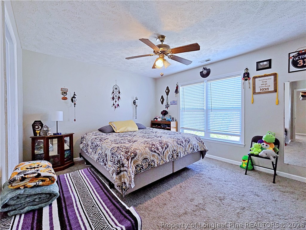 5218 Pringle Way Hope Mills, NC 28348 - Photo 22 of 43 a bedroom with a bed and a chandelier