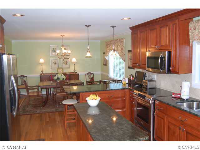 13620 Thorngate Road Midlothian, VA 23113 - Photo 3 of 12 a kitchen with stainless steel appliances wooden cabinets dining table and chairs
